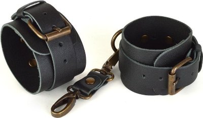 Черные кожаные наручники IDEAL Наручники изготовлены из натуральной кожи черного цвета. Соединяются перемычкой с двумя карабинами. Длина узкого ремешка с пряжкой - 31 см. Страна: Россия. Материал: натуральная кожа, металл.
