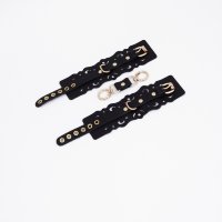 Черные кожаные наручники с узорами и золотистой фурнитурой